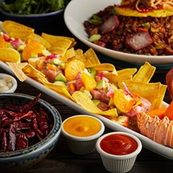 Peruvian ceviche with plantain chips, sauces, and a bowl of chaufa rice with char siu pork.