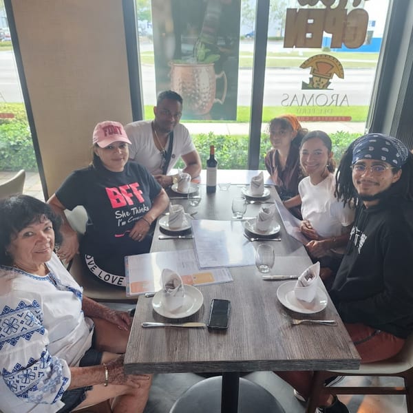 Six people, three men and three women, sitting around a table at Aromas del Peru restaurant.
