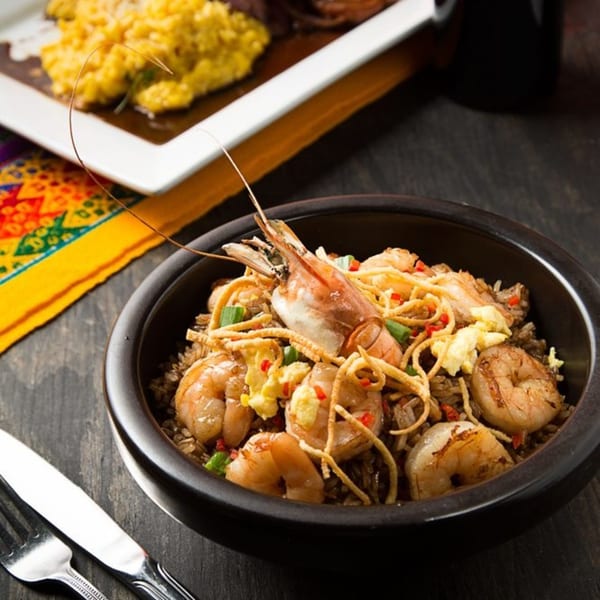 Aromas del Peru's Arroz con Camarones, a Peruvian shrimp and rice dish, in a black bowl.