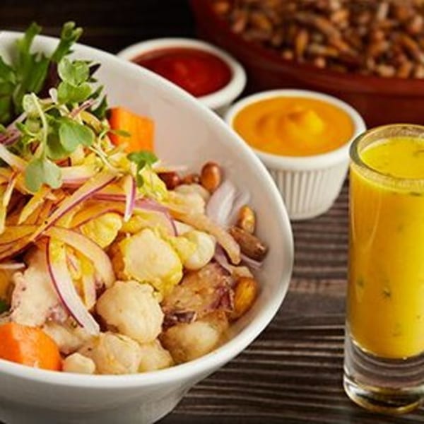 Peruvian ceviche with red onions, corn, sweet potato, and a shot of leche de tigre.